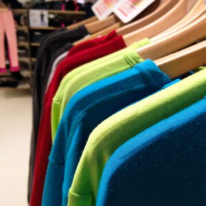 Colorful shirts on wooden hangers